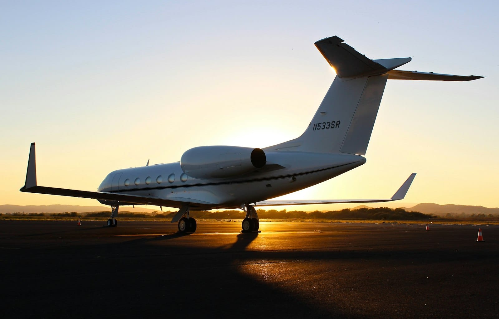 A private jet on the runway at sunset